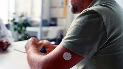 Close-up shot of middle-aged Caucasian man with diabetes sitting in gp clinic